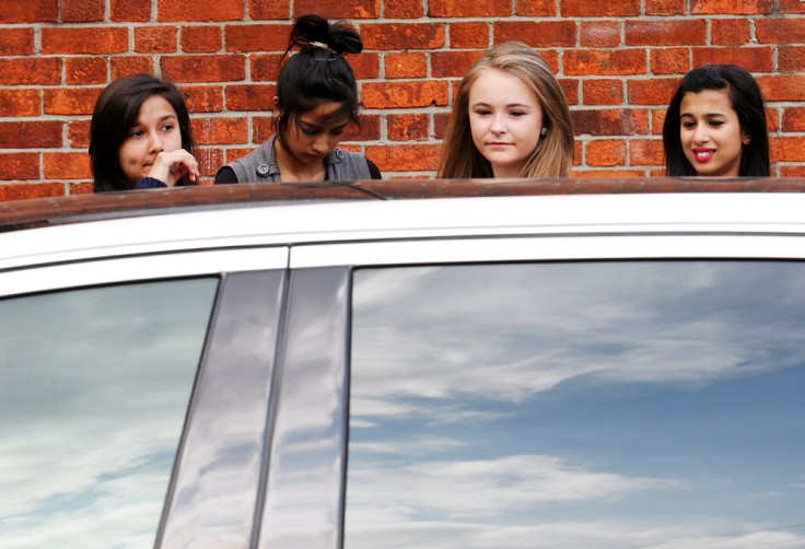 Teen girls looking at car