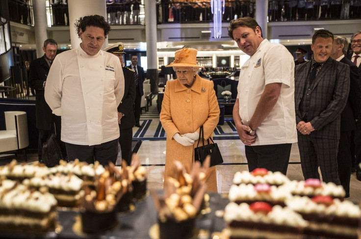 Britain's Queen Elizabeth looks at cakes and sweets on the patisserie counter with chefs Marco Pierre White (L) and James Martin