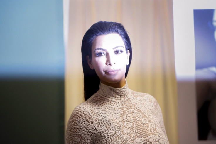 [7:48] Kim Kardashian is seen caught by a photographers flash while posing before the signing of her book 'Selfish'