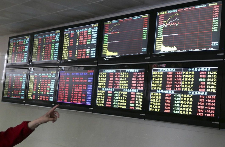 An investor points to computer screens showing stock information at a brokerage house in Nantong, Jiangsu province, China, May 11, 2015.
