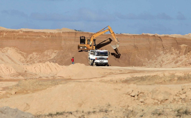 A excavator dumps bauxite ore into a dump truck at a mine belonging to China's Bosai Minerals Group in Linden, April 24, 2011.