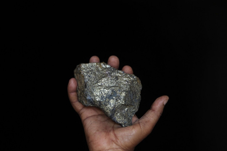A mine employee shows a piece of copper ore at the Kilembe mines