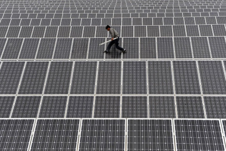 An employee walks on solar panels at a solar power plant in Aksu, Xinjiang Uyghur Autonomous Region May 18, 2012.