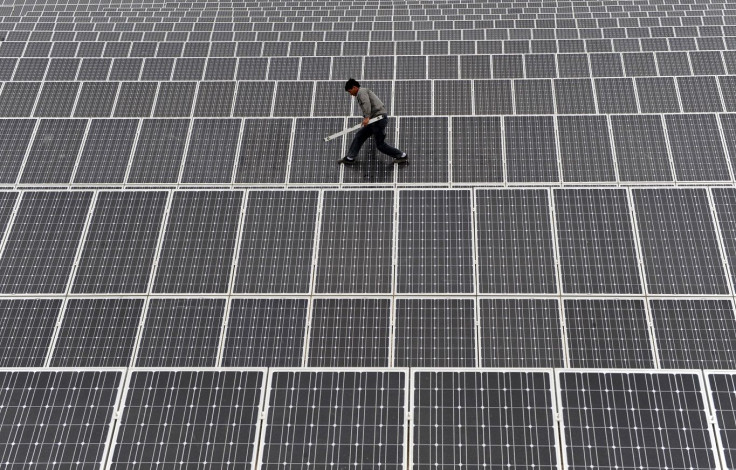 An employee walks on solar panels at a solar power plant in Aksu, Xinjiang Uyghur Autonomous Region May 18, 2012.