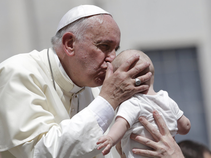 IN PHOTO: Pope Francis kisses a baby 