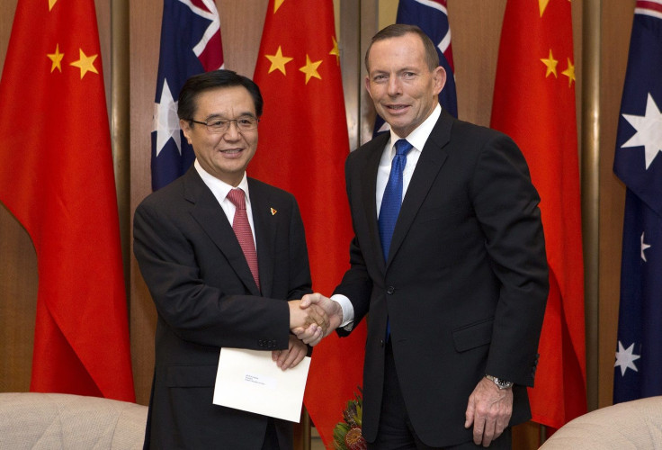 Australian Prime Minister Tony Abbott (R) shakes hands with China's Minister of Commerce Gao Hucheng