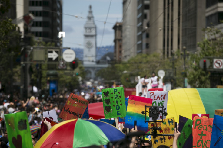 IN PHOTO: San Francisco's iconic ferry building is seen behind an assortment of signs and rainbow flags during a gay pride parade 