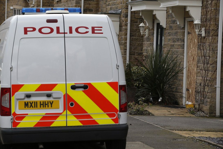 A police van sits outside a house in Mossley, northern England February 17, 2015.