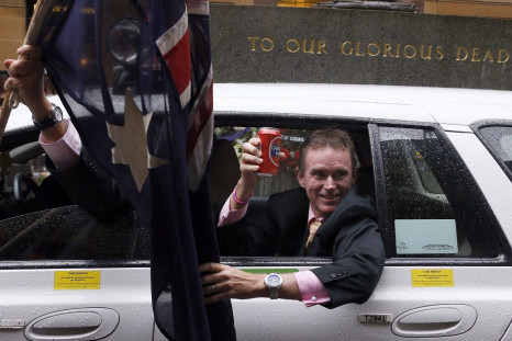 A man holds a can of beer as he leans out the window of a taxi as it passes the Cenotaph during the annual ANZAC Day march through central Sydney April 25, 2014.