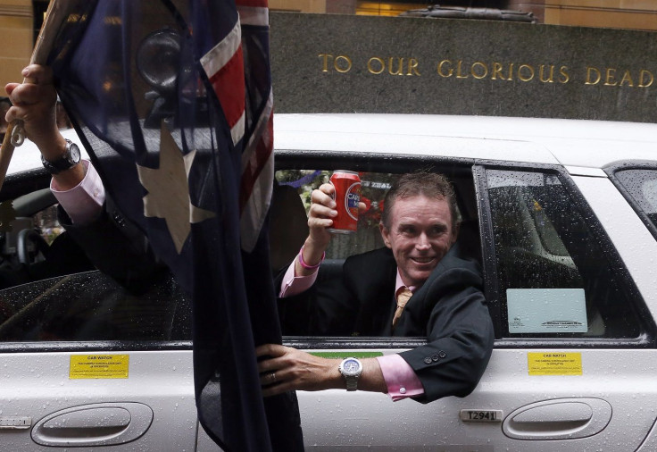 A man holds a can of beer as he leans out the window of a taxi as it passes the Cenotaph during the annual ANZAC Day march through central Sydney April 25, 2014.