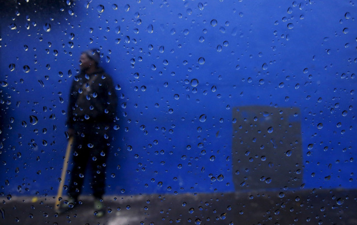 A job seeker is seen through a car window as he waits for casual work as a builder outside a hardware store in Cape Town, July 8, 2015.