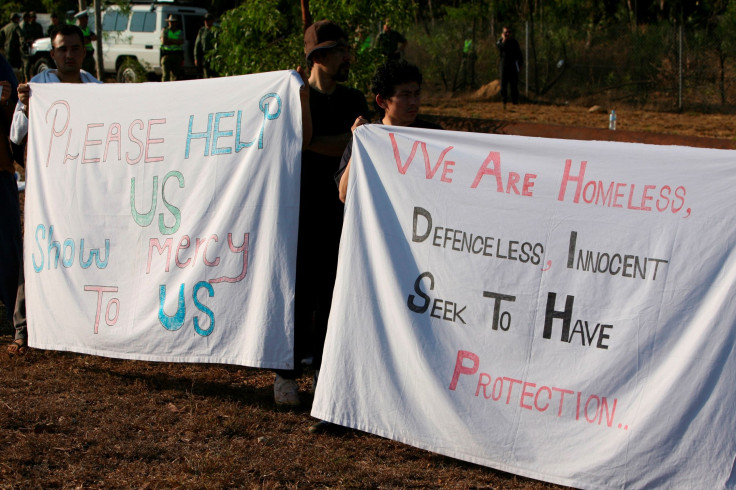 Escaped Afghan asylum seekers hold sheets as protest signs on the side of the road in Darwin September 1, 2010.