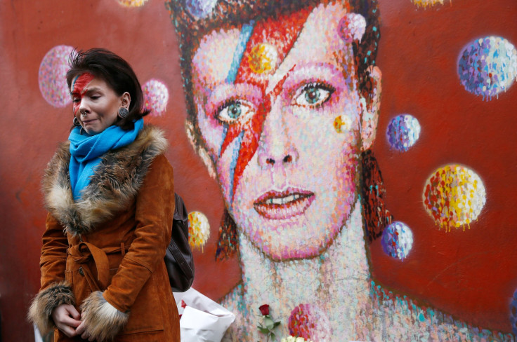 A woman wearing Ziggy Stardust-style make-up reacts as she visits a mural of David Bowie in Brixton, south London, January 11, 2016. 