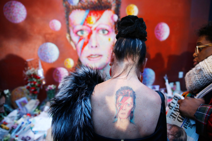 A woman with a Ziggy Stardust tattoo visits a mural of David Bowie in Brixton, south London, January 11, 2016. 