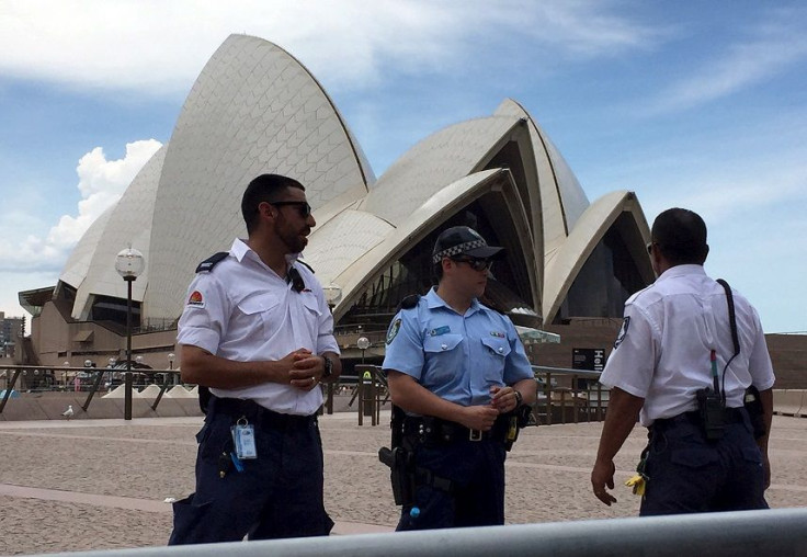 Police and security staff stand in front of the Sydney Opera House after it was evacuated due to a police operation January 14, 2016.