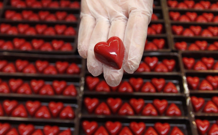 A worker displays a heart-shaped praline for Valentine's Day at a Wittamer chocolate boutique in Brussels February 14, 2012.