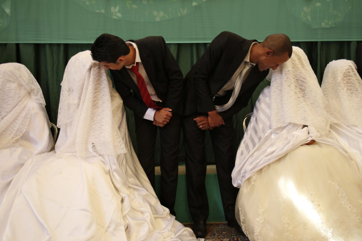 Brides speak to their grooms during a mass wedding ceremony in Amman.