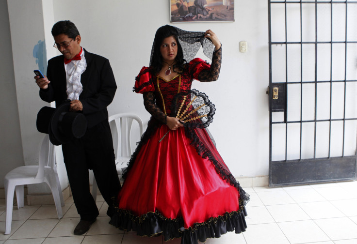 A couple wearing traditional clothes wait for the start of a mass wedding ceremony, in the district of Comas in Lima.