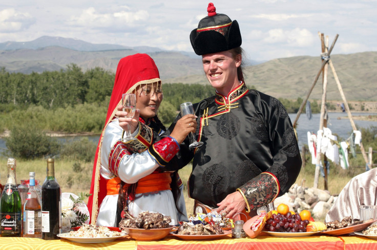 Sean Quirk (R), of U.S. from Milwaukee, Wisconsin, and his bride Chaiganmaa Ondar, originally from Tuva, wearing Tuvan national costumes, toast champage during their open-air wedding ceremony outside the city of Kyzyl.