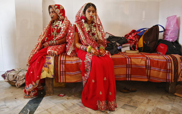 Brides sit after their make-up was done during a mass wedding ceremony at a temple in New Delhi.
