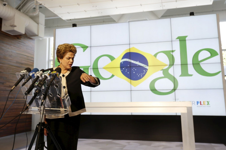 Brazil President Dilma Rousseff checks her watch as she addresses the media during her visit at Google headquarters