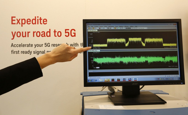 An exhibitor points to a screen displaying 5G spectrums during the Mobile World Congress in Barcelona March 5, 2015.