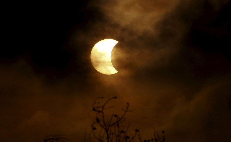 A partial solar eclipse is seen through clouds in Bangkok, Thailand, March 9, 2016.