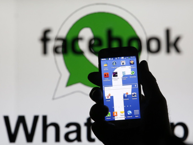 An illustration photo shows a man holding a smart phone with a Facebook logo as its screen wallpaper in front of a WhatsApp messenger logo, in Zenica February 20, 2014.