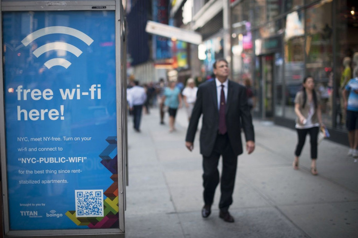 People walk past a WiFi-enabled phone booth in New York, July 12, 2012.
