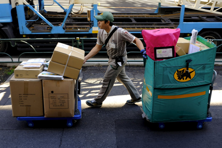 A delivery man moves carts with parcels in Tokyo, November 27, 2015. 