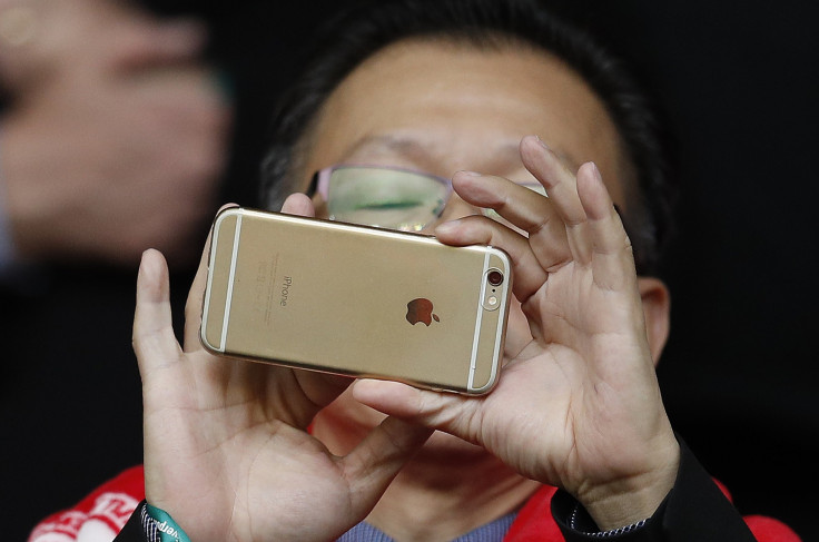 A man uses an Apple iPhone to take photographs before the Liverpool versus Tottenham Hotspur soccer match at Anfield in Liverpool northern England, April 2, 2016. 