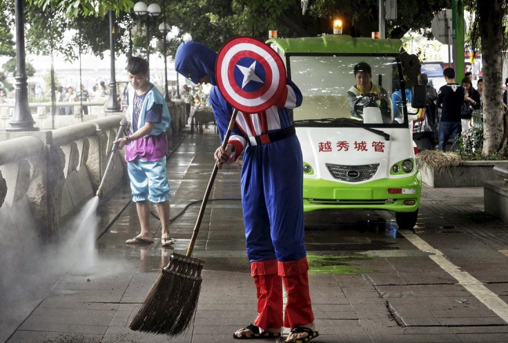 A student volunteer in a Captain America costume (front) sweeps the ground during a campaign to clean the streets to mark Earth Day, in Guangzhou, Guangdong province April 21, 2015.