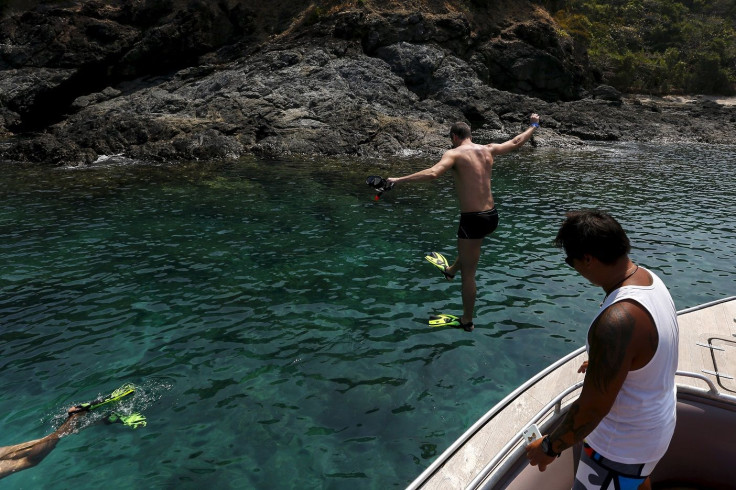 A tourist jumps into water near Maiton Island in Phuket, Thailand March 18, 2016