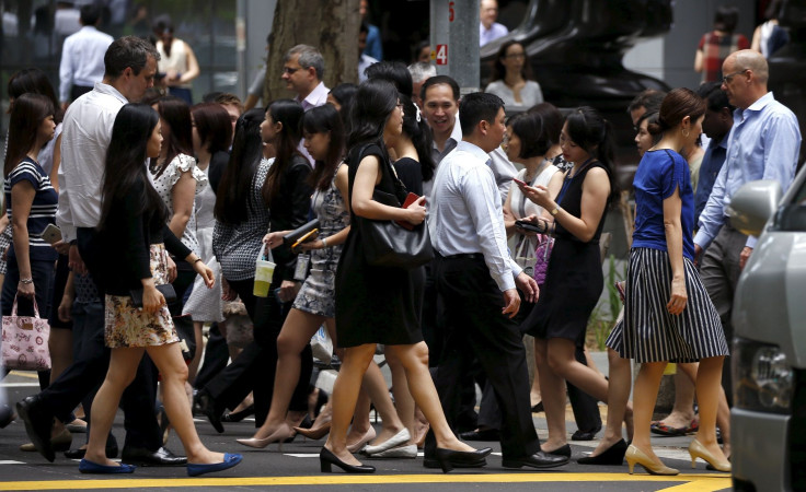 Office workers cross a street during lunch hour at the central business district in Singapore April 27, 2016.