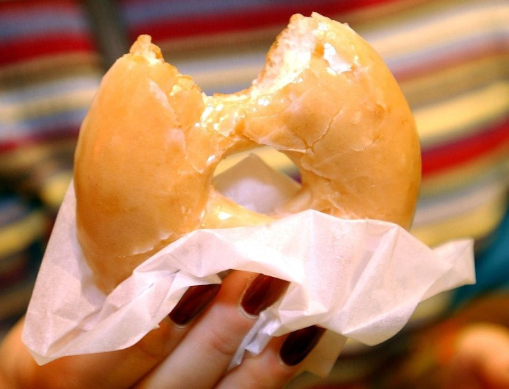 A customer samples a doughnut at the opening of the Krispy Kreme doughnut store at Harrods in London, October, 3, 2003.