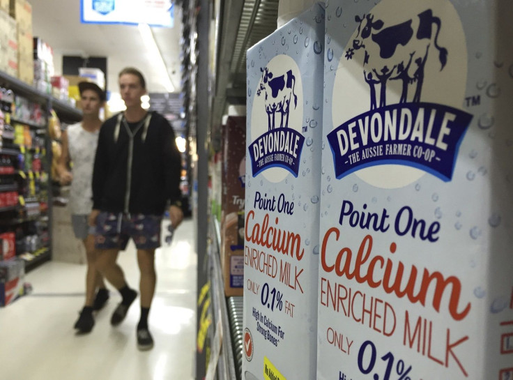 Shoppers walk past cartons of Devondale brand long life milk at a Sydney supermarket, April 12, 2016.