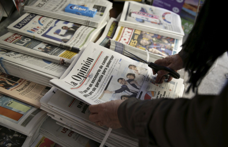 A woman prepares newspapers for sale at a kiosk in central Madrid, Spain, December 21, 2015.