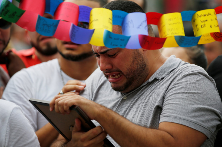 A friend of Amanda Alvear holds up her photo at a memorial service the day after a mass shooting at the Pulse gay nightclub in Orlando, Florida, U.S. June 13, 2016.