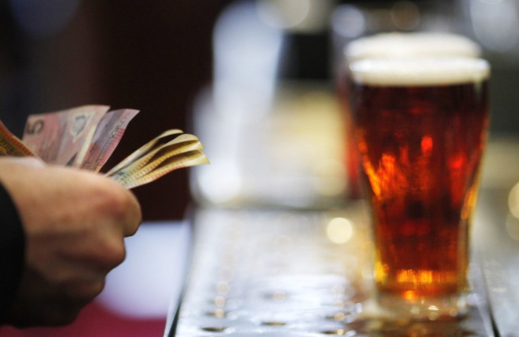 A customer pays for a Fosters beer at the Occidental Hotel in central Sydney June 21, 2011