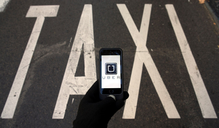 The logo of car-sharing service app Uber on a smartphone over a reserved lane for taxis in a street is seen in this photo illustration taken in Madrid on December 10, 2014.
