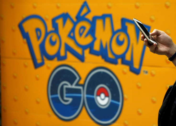A man uses a mobile phone in front of an advertisement board bearing the image of Pokemon Go at an electronic shop in Tokyo, Japan, July 27, 2016.