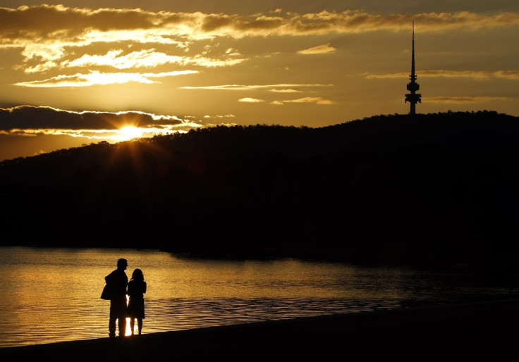 A couple looks towards the Black Mountain Tower as they watch the setting sun over Canberra's Lake Burley Griffin April 23, 2008.