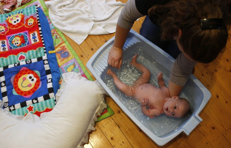 A woman bathes her baby at her house in suburban Melbourne May 11, 2009.