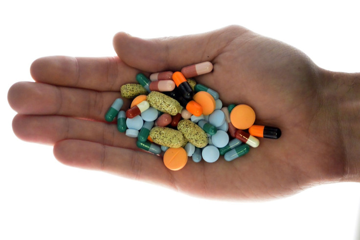 A person holds pharmaceutical tablets and capsules in this picture illustration taken in Ljubljana September 18, 2013.
