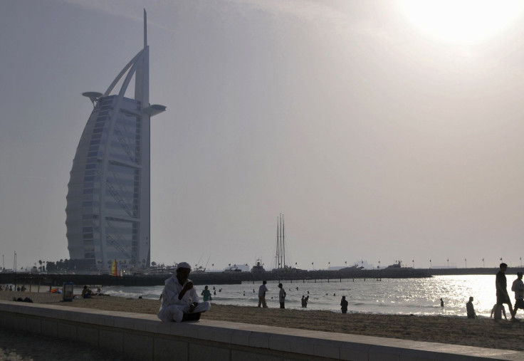 A man sits near a beach in Jumeirah in Dubai April 4, 2010.