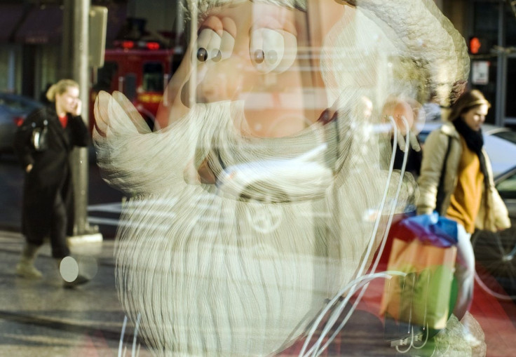 Shoppers walk past a reflection of a Santa Claus in the window of the Apple Store in the Back Bay neighborhood of Boston, Massachusetts November 28, 2008.