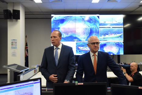 Australia's Prime Minister Malcolm Turnbull (R) and Immigration Minister Peter Dutton speak to officials during a tour of the Australian Maritime Border Command Centre in Canberra, November 13, 2016.
