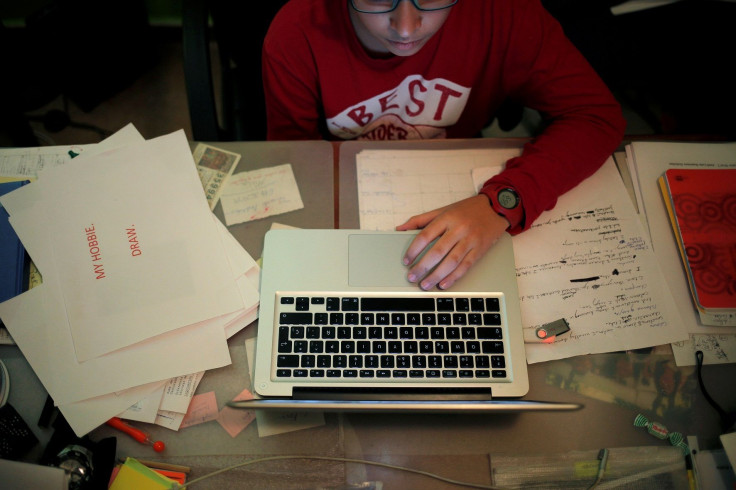 A boy uses a laptop as he does his homework at his home in Ronda, southern Spain