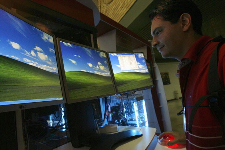 A man works simultaneously on three flat screens at an exhibition booth at the International Conference on Communication and Technologies in Havana February 16, 2007