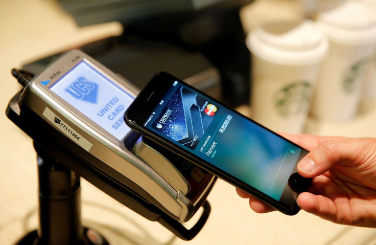 FILE PHOTO: A man uses an iPhone 7 smartphone to demonstrate the mobile payment service Apple Pay at a cafe in Moscow, Russia, October 3, 2016.